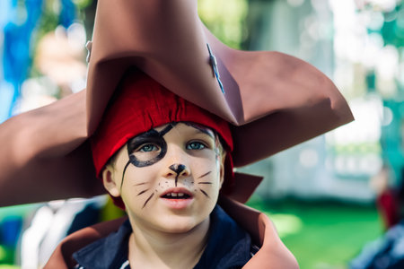 Boy Cat Pirate costume. Halloween party in kindergarten. Aqua makeup painted kids face. Bright festiveの写真素材