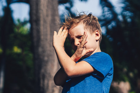 Child boy blue t-shirt karate pose, playing outside summer day. Happy childhood, family educationの写真素材