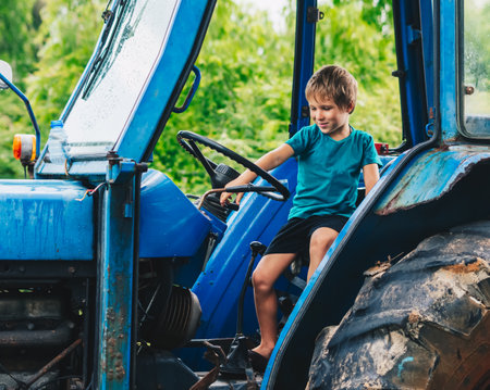 Funny boy sitting in tractor in summer, family education, happy joy childhood, exploring worldの写真素材