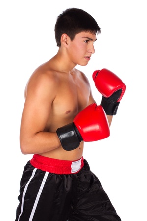 Young handsome male caucasian kickboxer wearing red boxing gloves and kickboxing gear isolated on a white backgroundの写真素材
