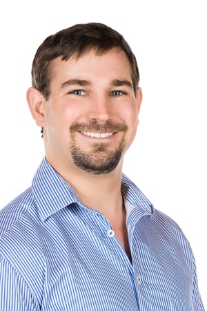 Closeup portrait of a young professional adult male wearing a blue buttoned shirt. Image is isolated on a white background.の写真素材