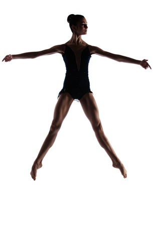 Silhouette of a beautiful female ballet dancer isolated on a white background  Ballerina is barefoot and wearing a dark leotard and short dress の写真素材