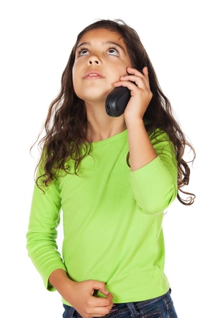 Pretty cute caucasian girl wearing a green long sleeve top and blue jeans. She is talking on a mobile phone.の写真素材