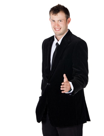 Handsome young successful caucasian businessman wearing a formal black suit, tie and white shirt. He is holding out his hand for a handshake and is smiling.の写真素材