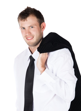 Handsome young successful caucasian businessman wearing a formal black suit, tie and white shirt. He is casually holding his jacket and smiling at the camera.の写真素材