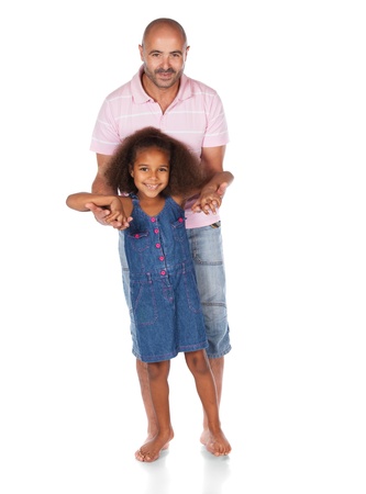 Adorable cute african child with afro hair wearing a denim dress is playing with her father. The dad is wearing a pink shirt and jeans.の写真素材