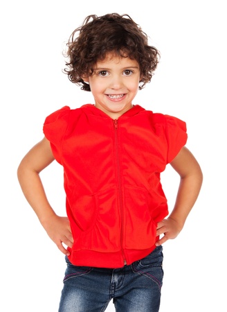 Adorable small caucasian child with curly hair wearing a bright red hooded top and blue jeans. The girl is standing and smiling at the camera.の写真素材
