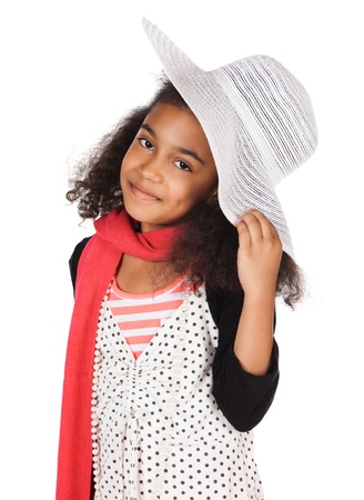 Adorable cute african child with afro hair is playing dress up. She is wearing a white dress with dots, a hat, scarf and high heel shoes.の写真素材