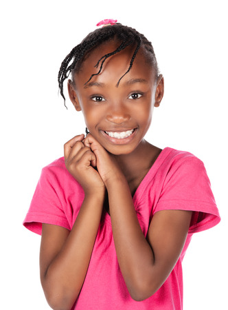 Adorable small african child with braids wearing a bright pink shirt. The girl is standing and smiling at the camera.の写真素材