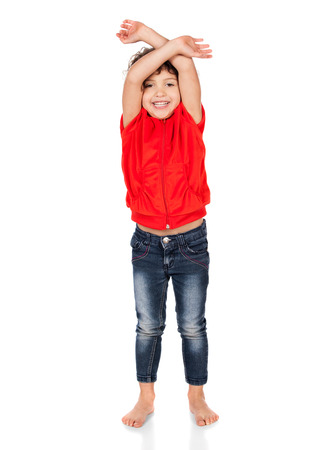 Adorable small caucasian child with curly hair wearing a bright red hooded top and blue jeans. The girl is waiving her arms.の写真素材