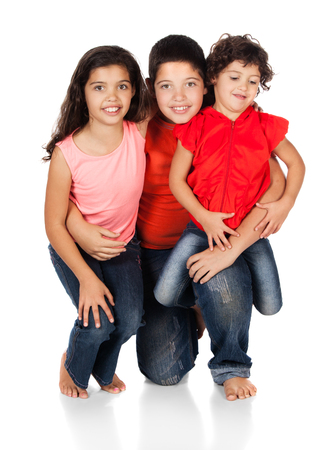 Two caucasian girls and one boy all wearing blue jeans. They are wearing orange, red and pink shirts.の写真素材