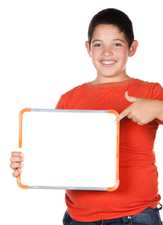 Young caucasian boy wearing an orange t-shirt and blue jeans. The boy is holding a small white board.の写真素材