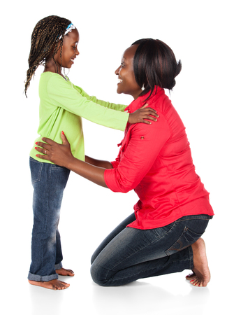 Adorable small african child with braids wearing a bright green shirt and blue jeans and her mother wearing a red shirt.の写真素材