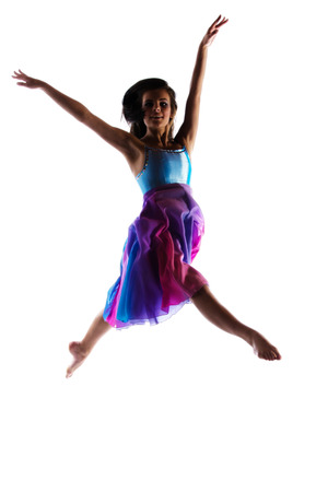 Silhouette of a beautiful female modern jazz contemporary style dancer isolated on a white background. Dancer is barefoot and wearing a blue and purple dress.の写真素材