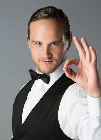 Portrait of a handsome caucasian man wearing a formal black suit with bow tie.の写真素材