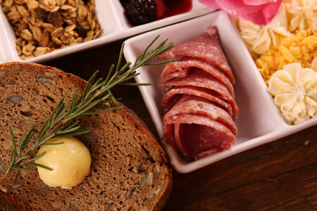 Full continental breakfast served on a wooden chopping board.の写真素材