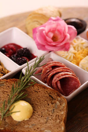 Full continental breakfast served on a wooden chopping board.の写真素材