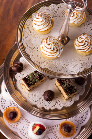 A selection of delicious desserts arranged and served on a silver cake stand in an english high tea style.の写真素材