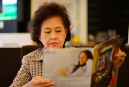 Portrait of asian senior woman reading newspaperの写真素材
