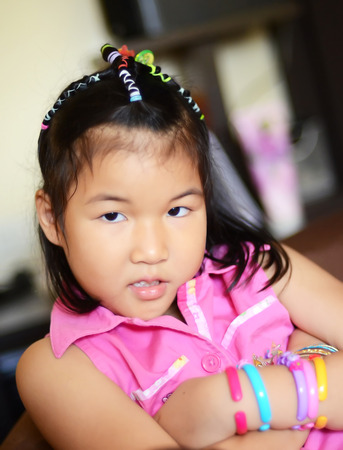 Closeup portrait of Asian little girl smile in pink dressの写真素材