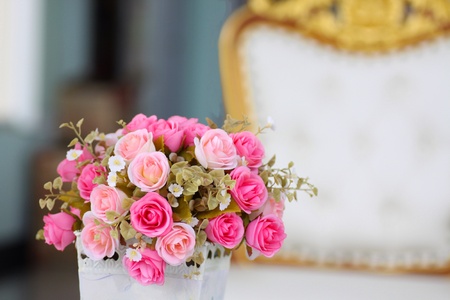 Tiny bouquet of pink roses in white vase.の素材