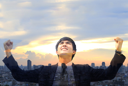 business man so glad as if he has got to success something with cityscape background , Double exposure styleの写真素材