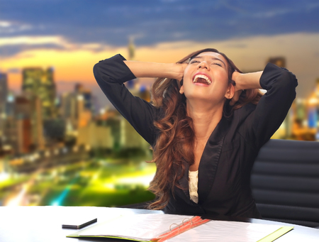 business woman scream something in her office with cityscape backgroundの写真素材