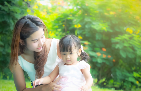 soft focus , close up portrait of Asian mother take care young daugther in gardenの写真素材