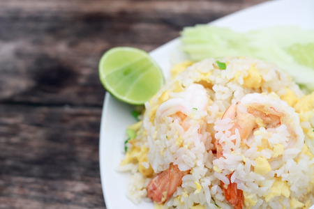 Fried rice with shrimp on the white dish on wooden tableの写真素材