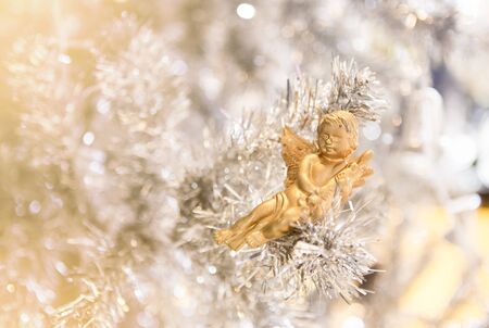cute golden doll decorated on white Christmas treeの写真素材
