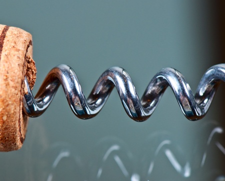 Corkscrew and cork on a glass table close upの写真素材