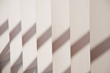 Fragment of blinds a beige fabric with shadow close upの写真素材