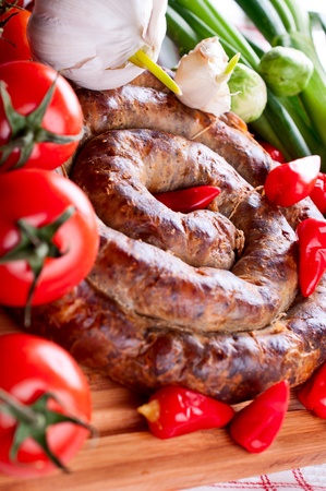 Sausage with spices, tomatoes and red pepper close upの写真素材