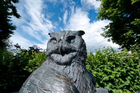 Statue of an Owl against a summer sky in Oslo botanical gardenの写真素材