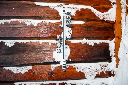 Frozen thermometer on a wooden wall of log cabinの写真素材
