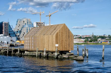 View on marina wooden house with modern buildings and cranes on backgroundのeditorial素材