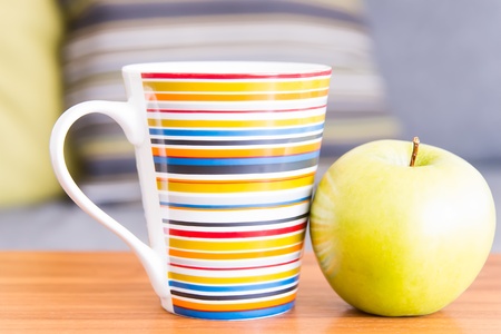 Cup and apple on wooden tableの写真素材
