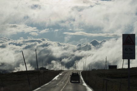 Mountain road with cars above cloudsの写真素材