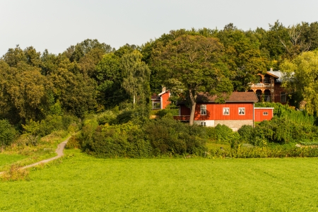 Alone red farmhouse on a meadow in forrestのeditorial素材