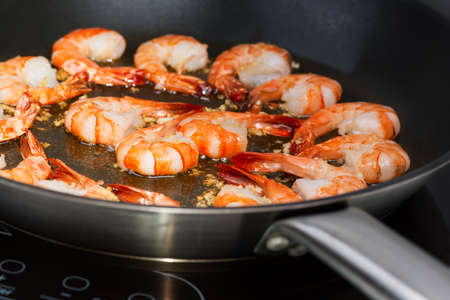 Chinese cooking: Shrimp in wok on cook topの写真素材