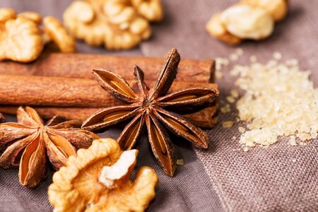 Star anise, walnut, brown sugar with cinnamon at christmas time on cloth backgroundの写真素材