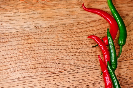Fresh red and green chili pepper on wooden table with copy space
