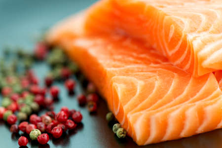 Raw salmon and pepper corns on plate close upの写真素材