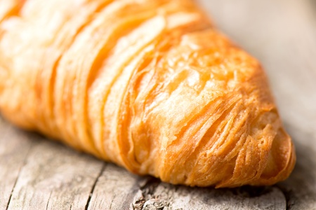 Fresh and tasty croissant on wooden tableの写真素材