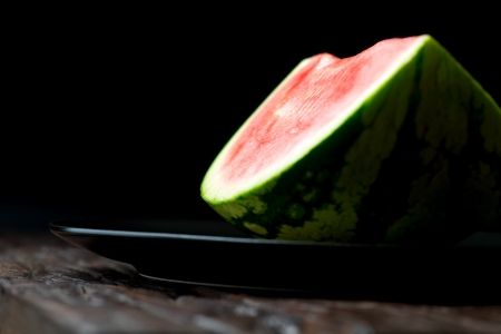 Close-up of red watermelon in plate on wooden tableの写真素材