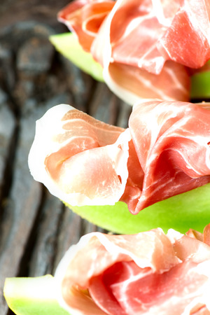 Serrano ham with melon on old wooden tableの写真素材