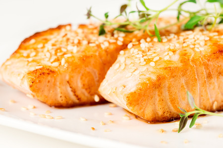 Grilled salmon, sesame seeds  and marjoram on white plate. Studio shotの写真素材