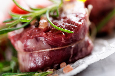 Raw beef steak with peppercorns and herbsの写真素材