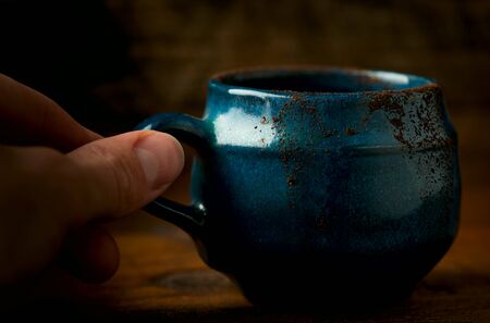 Coffee in grunge blue clay cup on rustic wooden backgroundの写真素材