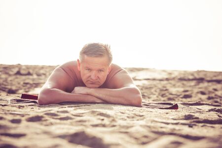 Man relaxing on sandy beachの写真素材